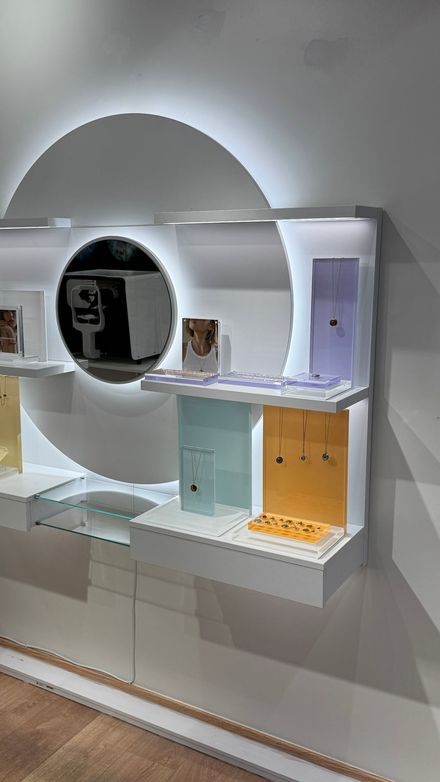 Circular backlit wall display with jewelry products staged on the shelves