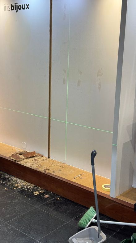 Wall corner stripped back during installation, with debris on the floor