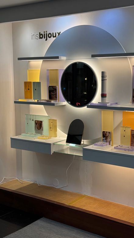 Finished circular backlit wall display with jewelry staged on the shelves