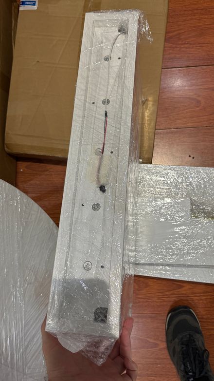 Wrapped mounting bracket component with wiring, held up before installation