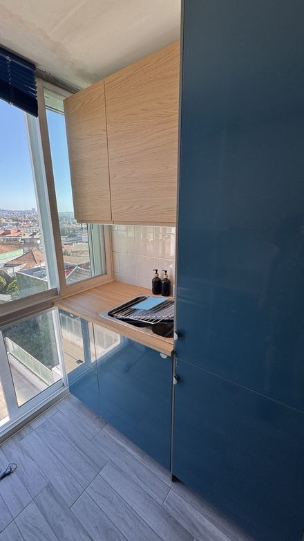 Completed IKEA kitchen with blue cabinets and wood worktop