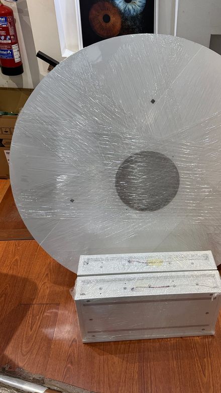 Wrapped circular panel and a boxed component on the floor