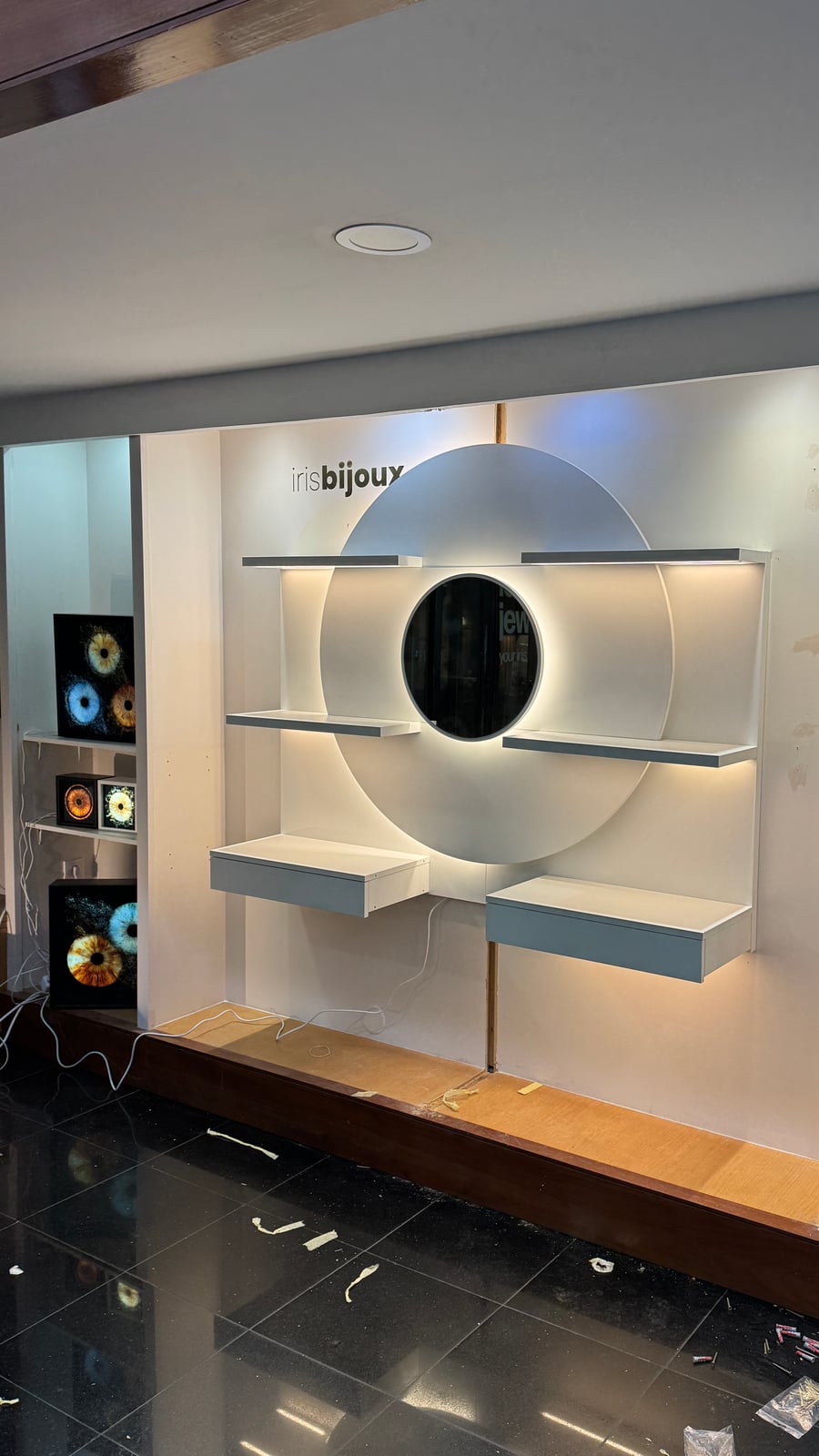 Iris Bijoux circular backlit wall display mounted, shelves not yet stocked with product