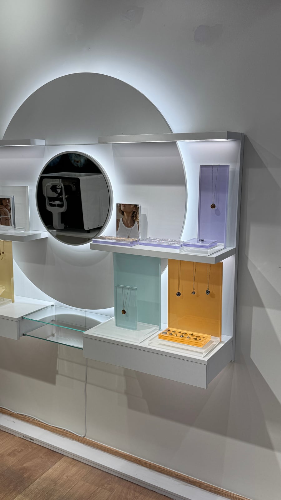 Circular backlit wall display with jewelry products staged on the shelves