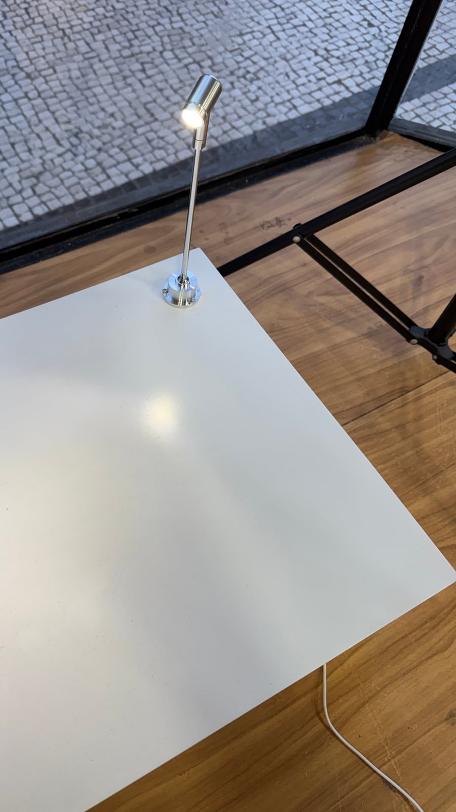 LED spotlight fixture mounted on a podium top, cable still visible