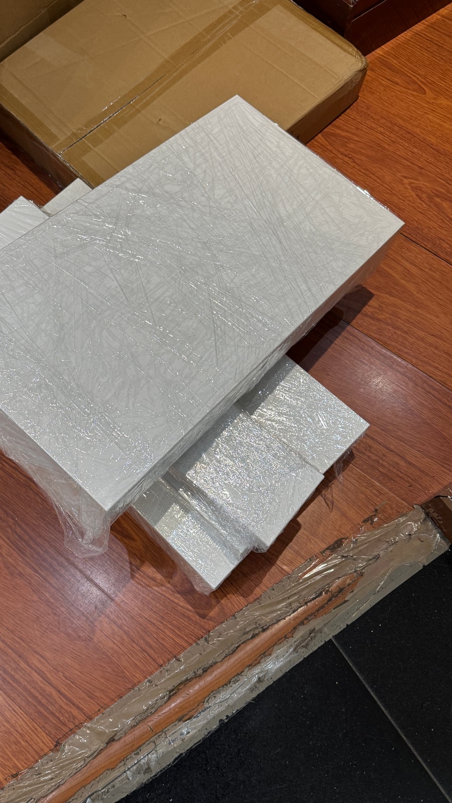 Wrapped rectangular panel components stacked on the floor
